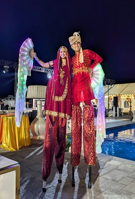 Bollywood-inspired stilt-walker in vibrant traditional costume at cultural celebration