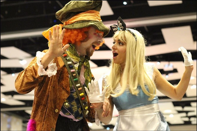 Mad Hatter and Alice in Wonderland stilt characters in close-up at corporate event