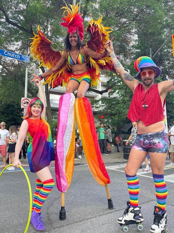 Pride stilt performer in rainbow costume at outdoor celebration