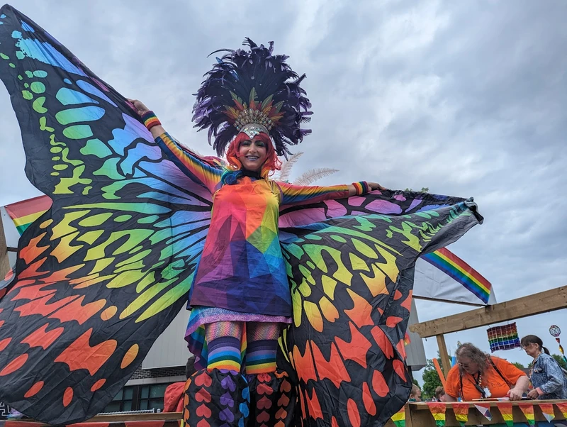 Pride stilt performers at outdoor celebration