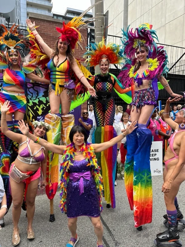 Pride stilt-walkers posing with VIP guests and performers at Toronto Pride celebrations